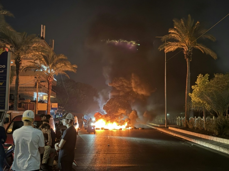 Des partisans du Hezbollah bloquent la route menant à l'ancien aéroport, dans la banlieue sud de Beyrouth, en brûlant des pneus pour protester contre l'accord trilatéral signé entre les Etats-Unis, Israël et le Liban le 27 juin 2026 ( AFP / Ibrahim AMRO )