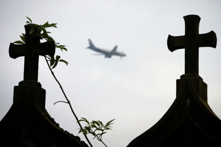 Un avion passe au-desusus du cimetière dans le village abandonné de Goussainville, le 26 novembre 2013, dans le Val-d'Oise ( AFP / JOEL SAGET )