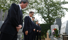 Tetsuro Kamata (3e g), sous-directeur général de la police de Tokyo, et des officiels présentent leurs excuses devant la tombe de Shizuo Aishima, plus de quatre ans après la mort de cet homme emprisonné à tort, le 25 août 2025 à Yokohama  ( JAPAN POOL / JIJI PRESS / STR )