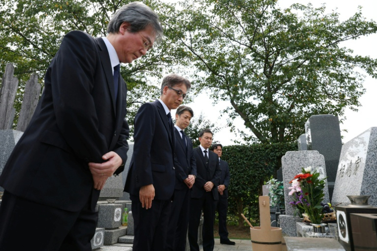 Tetsuro Kamata (3e g), sous-directeur général de la police de Tokyo, et des officiels présentent leurs excuses devant la tombe de Shizuo Aishima, plus de quatre ans après la mort de cet homme emprisonné à tort, le 25 août 2025 à Yokohama  ( JAPAN POOL / JIJI PRESS / STR )