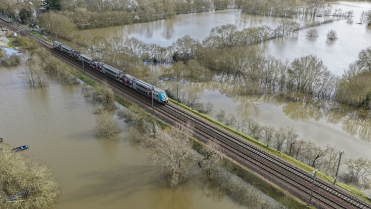 Vue aérienne d'un TER circulant sur une voie entourée de champs inondés, à Savennières, dans le Maine-et-Loire, le 17 février 2026 ( AFP / Damien MEYER )