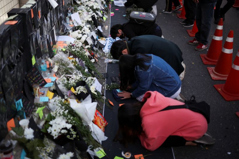 Des personnes se recueillent près du lieu de l'accident survenu lors des festivités d'Halloween, à Séoul