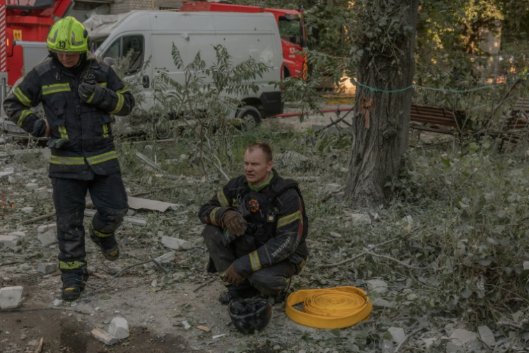 Des secouristes se reposent sur le site d'un immeuble résidentiel endommagé à la suite d'une frappe aérienne russe sur Kiev, le 2 juillet 2026 ( AFP / Roman PILIPEY )