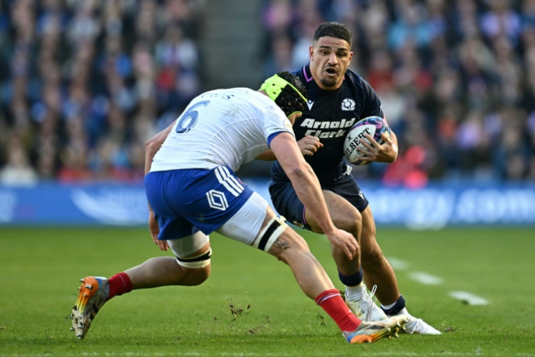 Le centre écossais Sione Tuipulotu (à droite) est plaqué par le troisième ligne français Francois Cros (à gauche) lors du Tournoi des six nations, le 7 mars 2026 à Edimbourg ( AFP / Paul ELLIS )