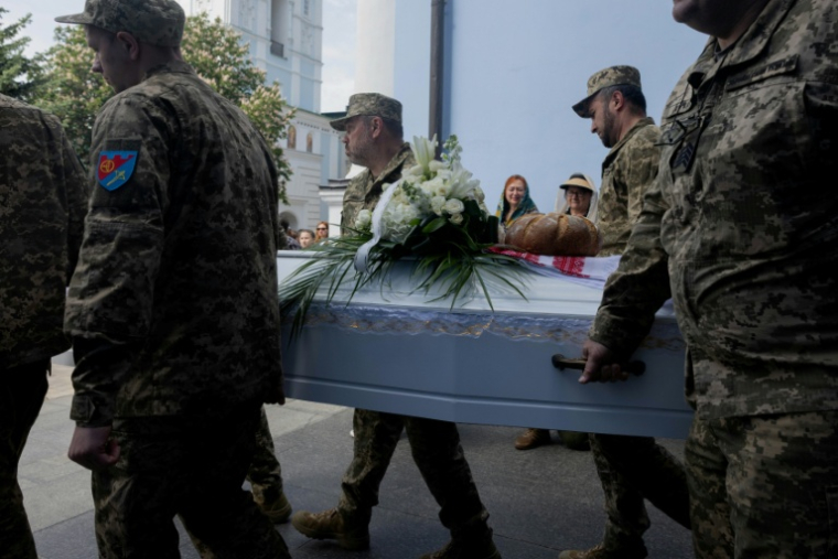Les cercueils de deux soeurs tuées par une frappe russe le 14 mai 2026 portés par des soldats ukrainiens lors de leurs obsèques le 19 mai 2026 ( AFP / Tetiana DZHAFAROVA )
