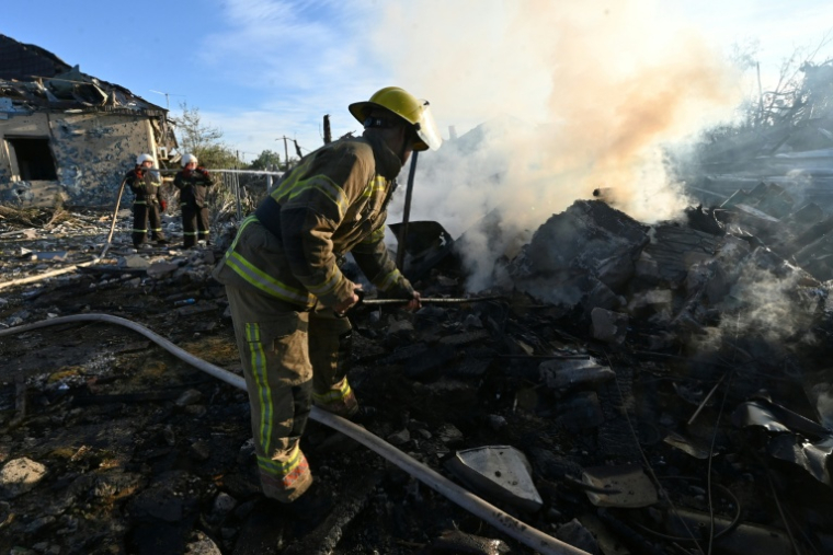 Des pompiers éteignent un incendie dans une maison à la suite de frappes aériennes à Kharkiv, le 2 octobre 2026 ( AFP / SERGEY BOBOK )