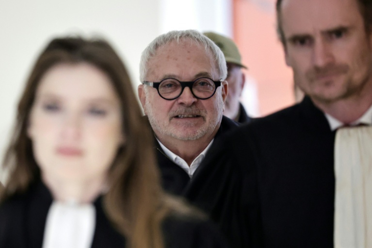 L'ancien sénateur Joël Guerriau (c) arrive  au Palais de justice de Paris pour son procès, le 26 janvier 2026, accusé d'avoir drogué la députée Sandrine Josso pour la violer ( AFP / STEPHANE DE SAKUTIN )