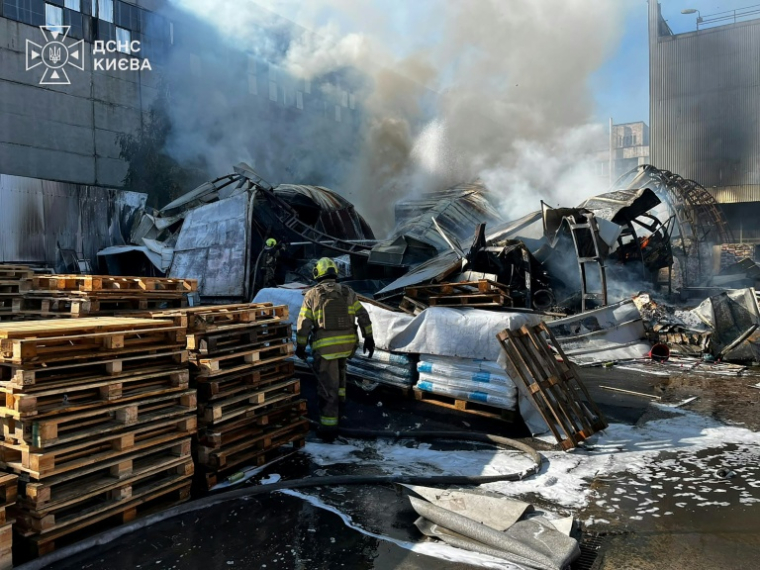 Photo diffusée par le Service d'État des situations d'urgence de l'Ukraine, prise le 8 octobre 2026, montrant des pompiers luttant contre un incendie dans un entrepôt à Kiev, après d'une frappe aérienne russe ( Ukrainian State Emergency Service / Handout )