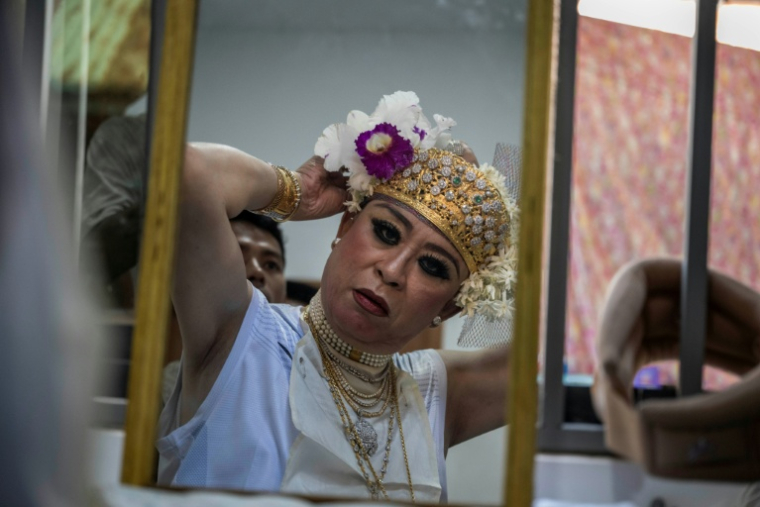 Une "épouse d'esprit" se prépare avant d'exécuter une danse rituelle lors du festival annuel des esprits de Taungbyone, dans la commune de Madaya située dans la région de Mandalay, en Birmanie, le 26 août 2026 ( AFP / SAI AUNG MAIN )