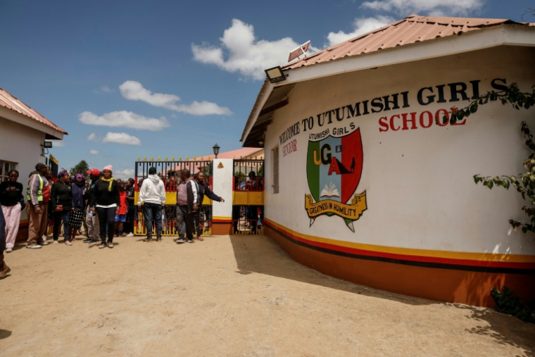 Des parents et tuteurs devant l'école pour filles Utumishi où est survenu un incendie meurtrier, le 28 mai 2026 à Gilgil, au Kenya ( AFP / SIMON MAINA )