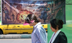 Une Iranienne passe devant une banderole représentant l'attaque américano-israélienne contre l'Iran, dans la capitale Téhéran, le 9 mai 2026 ( AFP / ATTA KENARE )