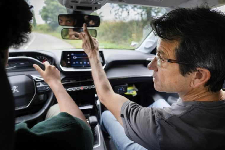 Le moniteur d'auto-école Jean-Luc Cossec et un de ses élèves, le 24 juillet 2025 à Quimper ( AFP / Fred TANNEAU )