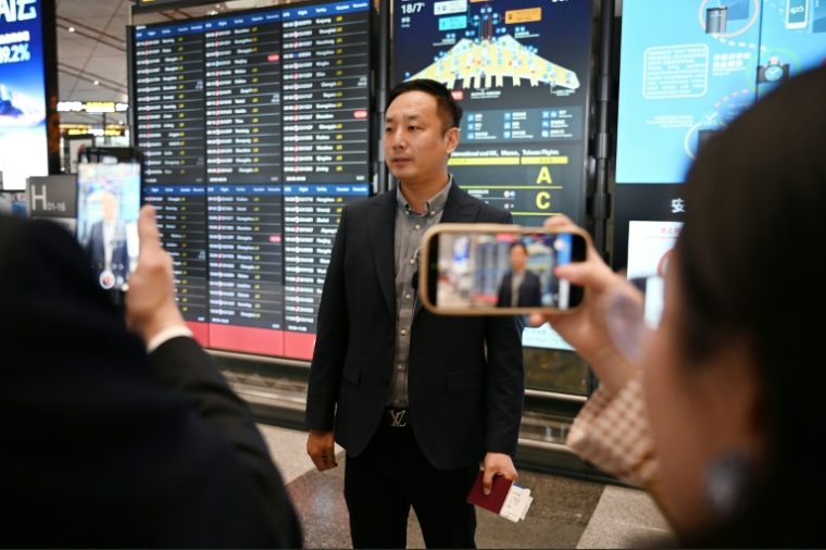 Zhao Bin, un homme d'affaires chinois, avant d'embarquer à l'aéroport de Pékin sur un vol Air China à destination de la capitale nord-coréenne Pyongyang, le 30 mars 2026 ( AFP / GREG BAKER )