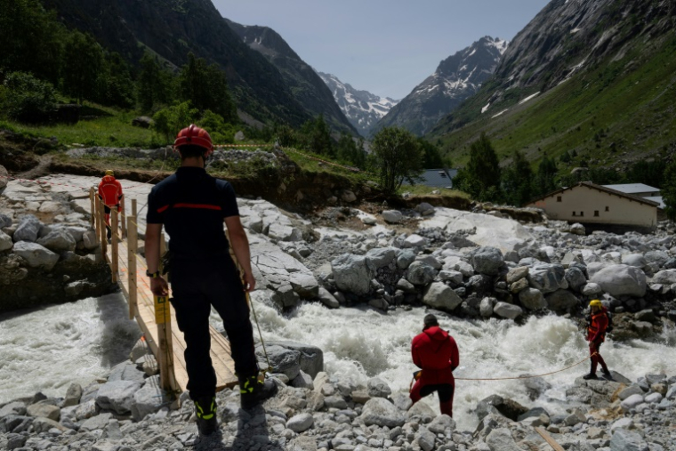 Des secouristes sécurisent une passerelle au-dessus d'une rivière après une crue dévastatrice de la rivière Veneon, le 21 juin 2024, dans le hameau de La Berarde, le 28 juin 2024 en Isère ( AFP / ARNAUD FINISTRE )