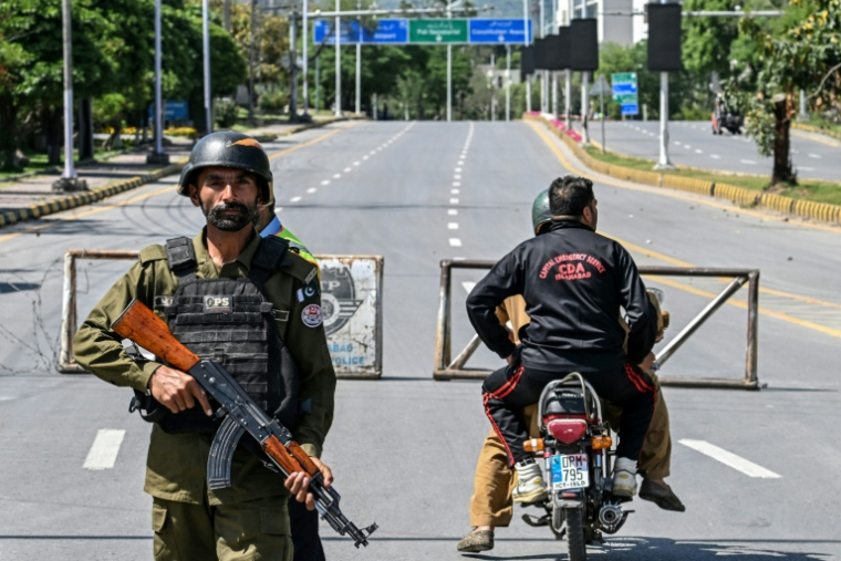 Des membres des forces de l'ordre tiennent la garde devant une route fermée menant à l'hôtel Serena, à Islamabad (Pakistan), le 19 avril 2026 ( AFP / Aamir QURESHI )