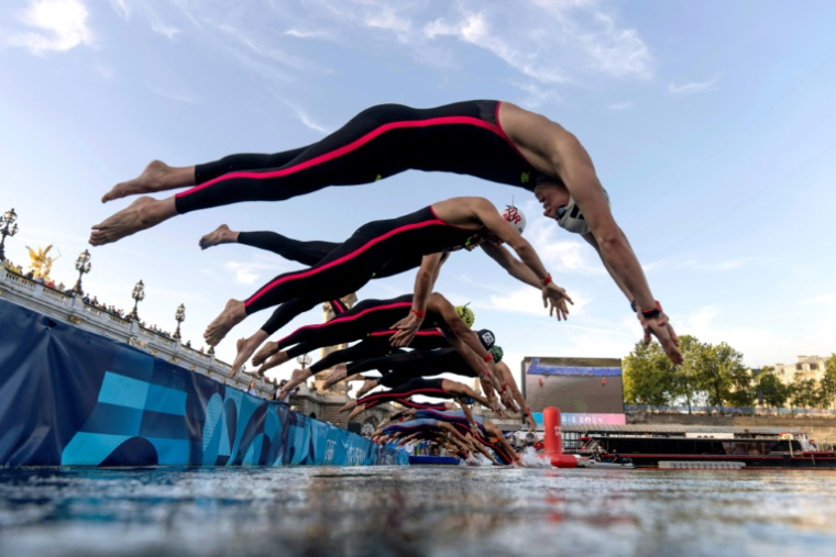Des athlètes plongent dans la Seine depuis le pont Alexandre III à Paris pour prendre le départ de la finale masculine du marathon de natation de 10 km aux Jeux Olympiques de Paris 2024, le 9 août 2024 ( POOL / David Goldman )