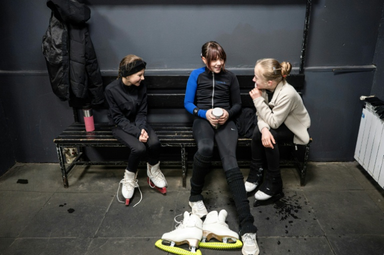 Trois jeunes patineuses prennent une pause lors d'un entraînement dans une patinoire de Kiev, le 16 octobre 2026  ( AFP / Genya Savilov )