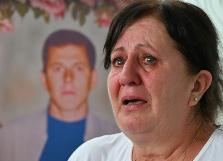 Mevlida Omerovic lors d'une interview avec l'AFP à Srebrenica, en Bosnie, le 7 juillet 2025, devant une image composite numérique de son mari Hasib, tué en 1995 ( AFP / ELVIS BARUKCIC )
