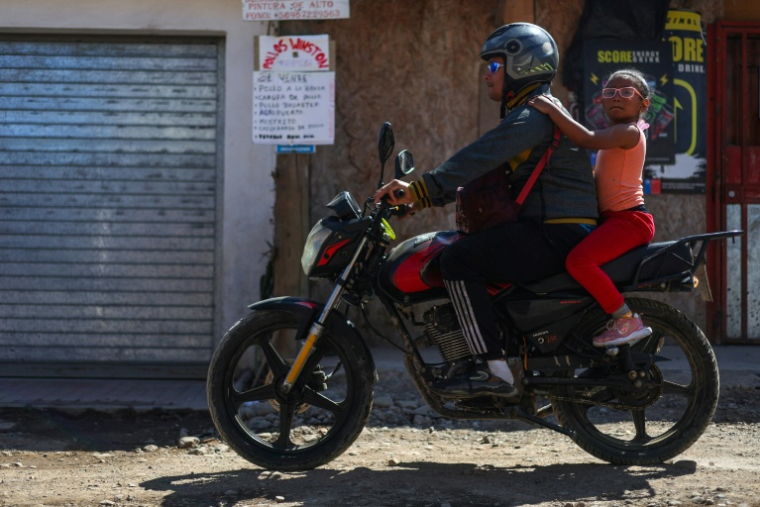 Une moto passe dans le quartier Nuevo Amanecer, à Santiago du Chili, le 11 novembre 2025 ( AFP / Javier TORRES )