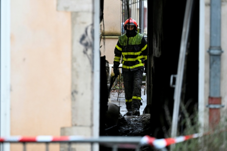 Un pompier dans le bâtiment où s'est déclaré dans la nuit un incendie mortel à Neuves-Maisons, en Meurthe-et-Moselle, le 30 novembre 2025  ( AFP / Jean-Christophe VERHAEGEN )