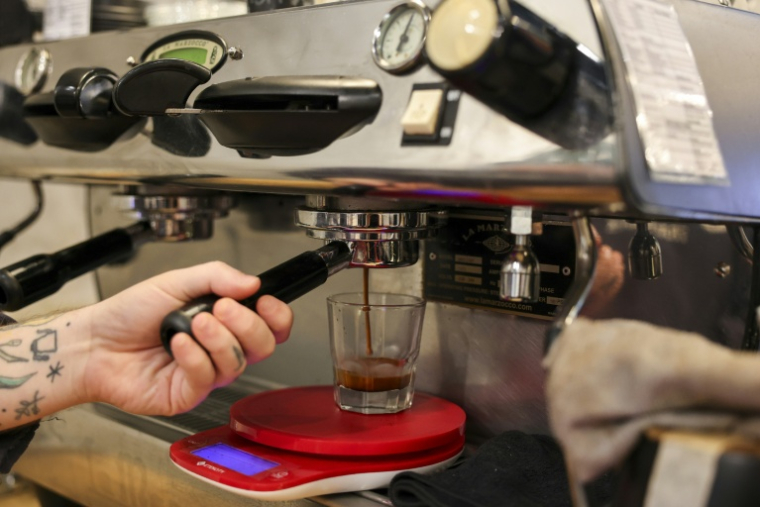 Un serveur prépare un café dans un "coffee shop" de New York, le 16 octobre 2025. ( AFP / ANGELA WEISS )