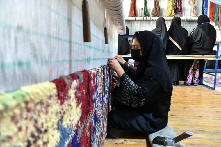 Une Afghane travaille dans un atelier de tissage de tapis à Nahr-e-shahi, dans le nord de l'Afghanistan, le 6 juillet 2026 ( AFP / Atif ARYAN )