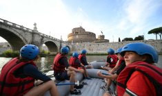 Des personnes naviguent en canot pneumatique sur le Tibre, passant devant le château Saint-Ange, sur un tronçon du fleuve situé entièrement dans la zone urbaine du centre de Rome, le 14 août 2026. ( AFP / Andreas SOLARO )