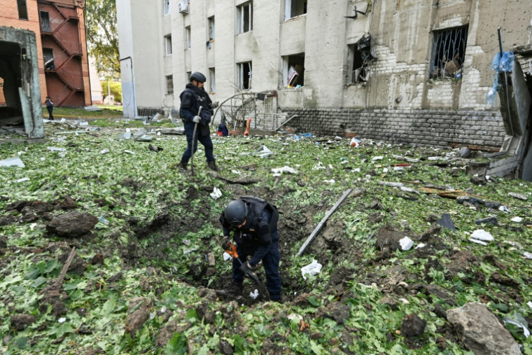 Des policiers dégagent les débris causés par une frappe de drone russe près d’un immeuble résidentiel endommagé à Kharkiv en Ukraine, le 7 juillet 2025 ( AFP / SERGEY BOBOK )
