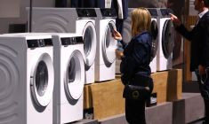 Des personnes regardent des machines à laver