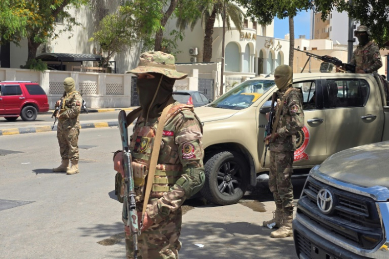 Des membres des forces de sécurité à un point de contrôle à Tripoli, le 13 mai 2025 en Libye ( AFP / Mahmud Turkia )