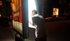 Un membre du Clan du Néon éteint le néon d’une publicité pour économiser l’électricité à Grenoble, le 9 juillet 2012 (Illustration). ( AFP / JEAN-PIERRE CLATOT )