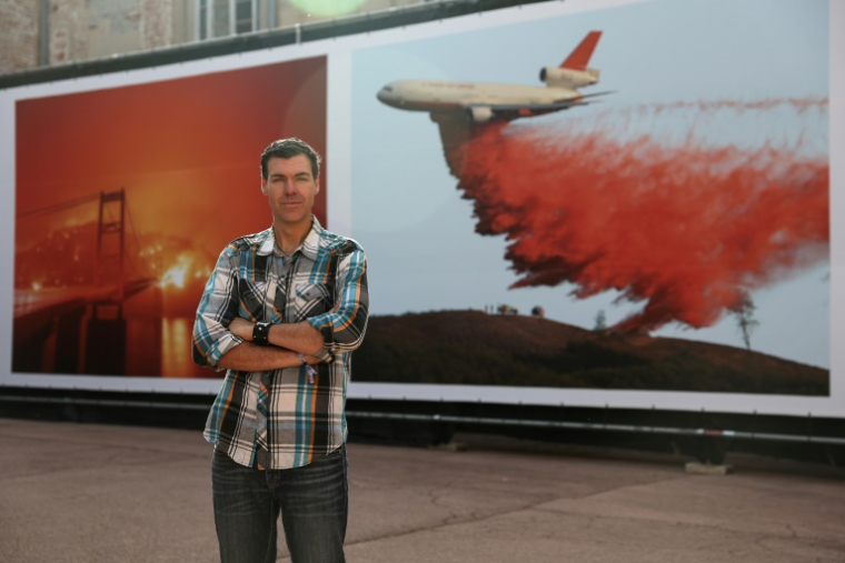 Le photographe américain de l'AFP Josh Edelson devant ses photos lors du festival Visa pour l'Image à Perpignan, le 2 septembre 2025 ( AFP / Valentine CHAPUIS )