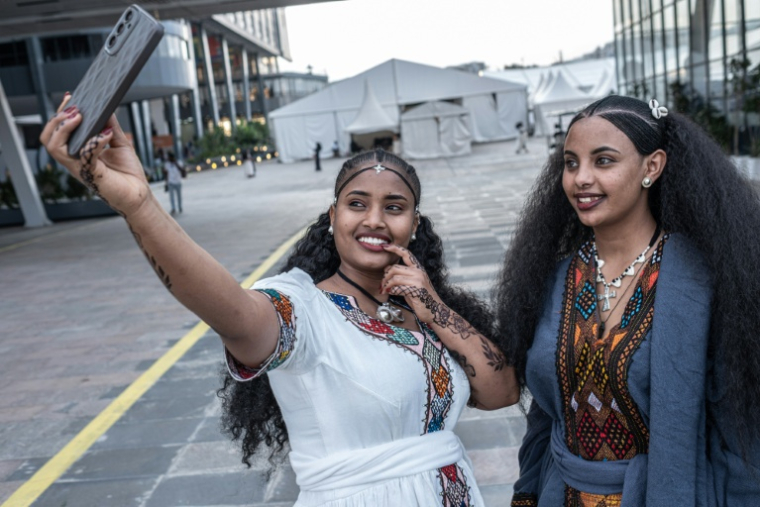 Les Tigréennes Tsadeye Werash (à gauche) et Tiras Gebregziabher, en robes et coiffures traditionnelles, célèbrent à Addis Abeba, le 22 août 2026, la fête d'Ashenda, originaire du Tigré ( AFP / Marco Simoncelli )