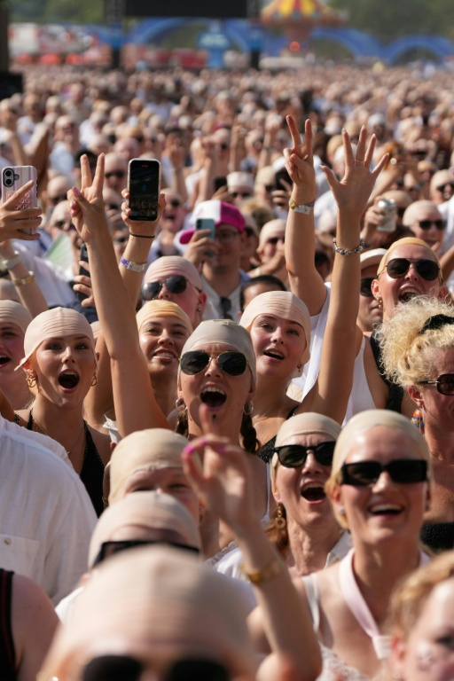 Des fans du rappeur américain Pitbull portent de faux crânes chauves avant un concert de l'artiste, le 10 juillet 2026 à Londres  ( AFP / CARLOS JASSO )