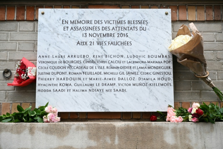Des fleurs ornent une plaque commémorative en face du bar "La Belle Équipe", le 13 novembre 2023 à Paris, à l'occasion du huitième anniversaire des attentats de Paris du 13 novembre 2015 ( POOL / Bertrand GUAY )