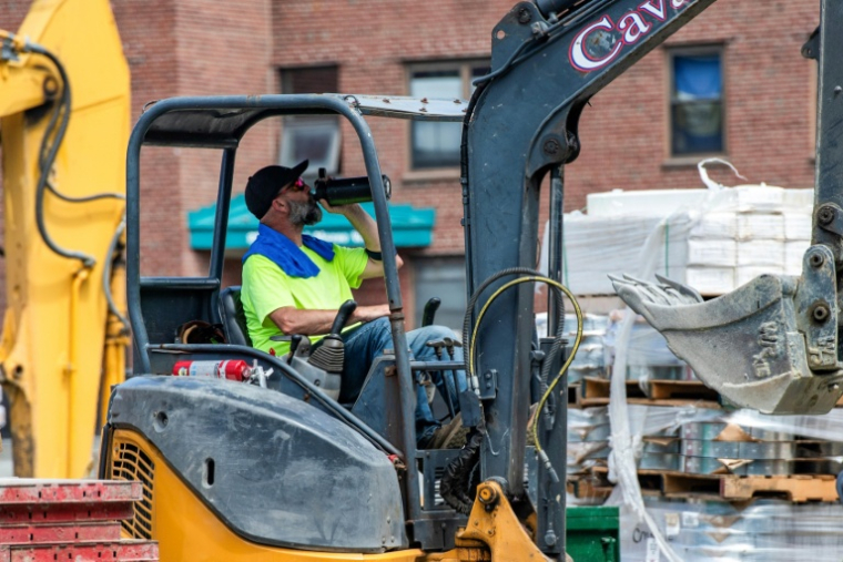 Un ouvrier boit de l'eau sur un chantier à Boston, dans le Massachusetts, le 1er juillet 2026, pendant une vague de chaleur aux Etats-Unis ( AFP / Joseph Prezioso )
