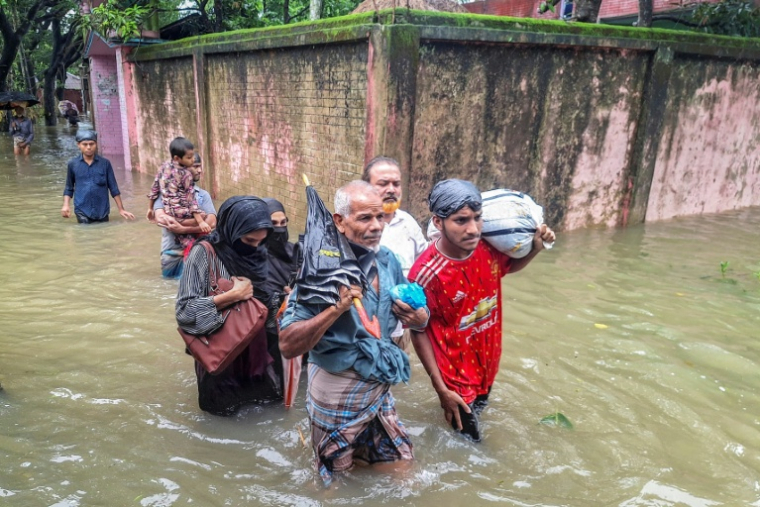 Des habitants avancent dans les eaux après de fortes pluies de mousson à Chattogram, au Bangladesh, qui ont déjà tué au moins 50 personnes  en une semaine, le 12 juillet 2026 ( AFP / Rabin Chowdhury )
