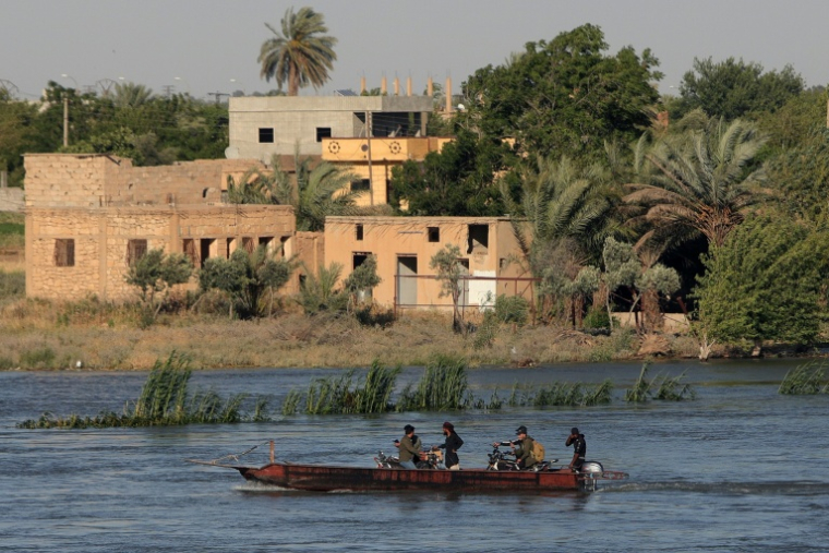 Des habitants traversent l'Euphrate en bateau dans la province syrienne de Deir Ezzor, en proie à des inondations, le 30 mai 2026 ( AFP / Bakr ALKASEM )