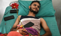 L'étudiant Aditya Rawal, blessé par balles par la police lors des manifestations contre le blocage des réseaux sociaux et la corruption au Népal, couché sur son lit à l'hôpital public de Katmandou, le 14 septembre 2025 ( AFP / Pedro PARDO )