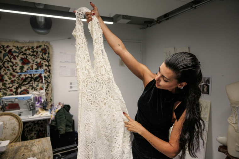 La créatrice, directrice artistique et styliste espagnole Maria Bernad, fondatrice de l'atelier Les Fleurs Studio, travaille sur une pièce réalisée à partir de dentelles anciennes, le 5 mai 2026 à Paris ( AFP / SIMON WOHLFAHRT )
