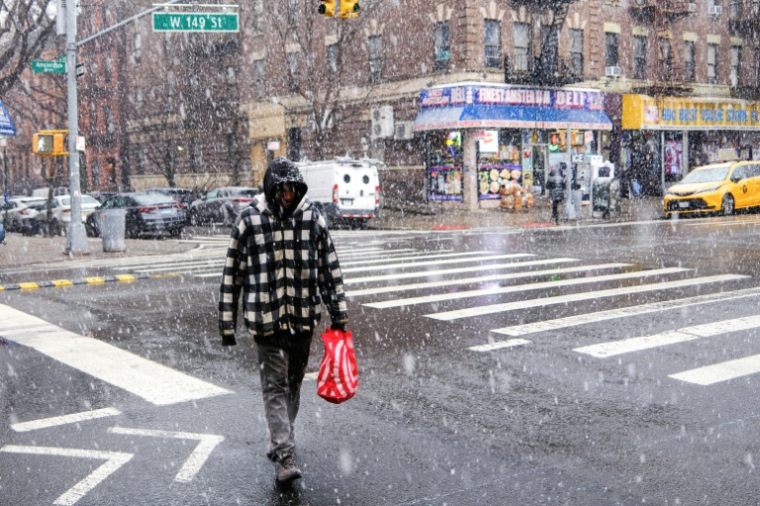 Un passant sous la neige dans une rue de New York, le 17 janvier 2026 ( AFP / CHARLY TRIBALLEAU )