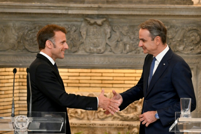 Le président français Emmanuel Macron (G) serre la main du Premier ministre grec Kyriakos Mitsotakis à l'issue d'une conférence de presse, le 25 avril 2026 à Athènes  ( AFP / Aris MESSINIS )