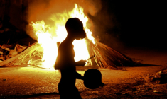 Un habitant tape sur une casserole devant un feu allumé lors d'une protestation contre les coupures de courant et les pénuries d'énergie à La Havane, le 14 mai 2026 à Cuba ( AFP / Yamil LAGE )
