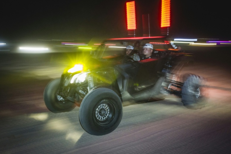 Deux hommes participent à une course nocturne dans leur buggy, près de Somerton, en Arizona, le 18 octobre 2026 ( AFP / Olivier Touron )