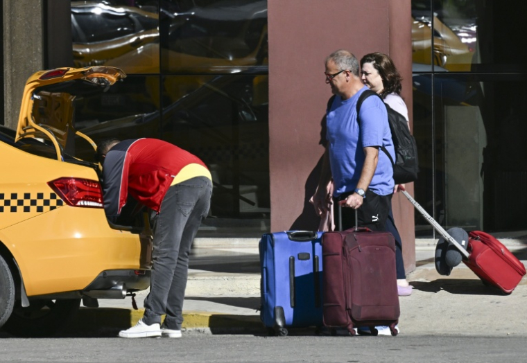 Des touristes prennent un taxi dans une rue de La Havane, le 11 février 2026 à Cuba ( AFP / YAMIL LAGE )