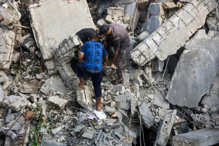 Des Palestiniens cherchent les corps de victimes de bombardements israéliens dans les décombres, le 29 octobre 2025 dans la ville de Gaza ( AFP / Omar AL-QATTAA )