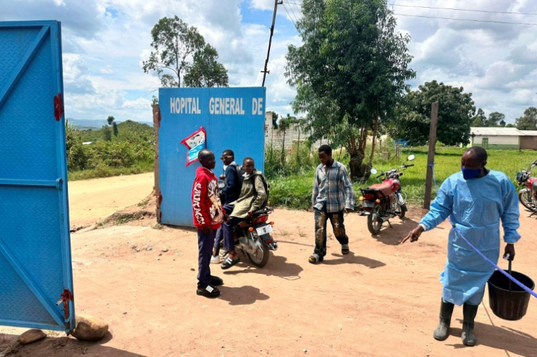 Un membre du personnel porte un équipement de protection à l'entrée de l'hôpital de Rwampara, l'un des foyers de l'épidémie d'Ebola, le 19 mai 2026 en RDC ( AFP / Jorkim Jotham PITUWA )