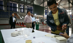 Le chef de la junte birmane Min Aung Hlaing (centre) observe le vote dans un bureau de Mandalay lors des législatives du 25 janvier 2026  ( AFP / ANTHONY WALLACE )