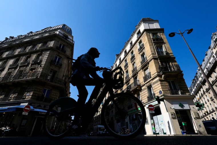 Un homme roule à vélo près de l'endroit où un gang masqué a tenté d'enlever la fille d'un crypto-entrepreneur, à Paris
