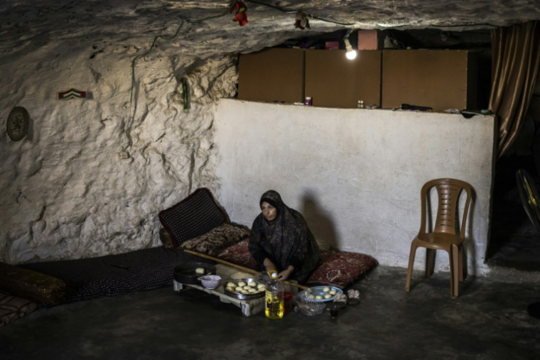 Fatma Amr prépare des gâteaux dans la grotte que sa famille a aménagée en habitation dans le village d'Al-Tuwani, en Cisjordanie occupée par Israël, le 11 septembre 2026 ( AFP / John WESSELS )